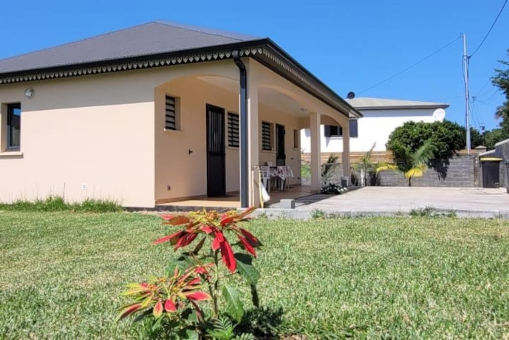 uma casa com um relvado verde em frente em Ti coin jardin em La Paix