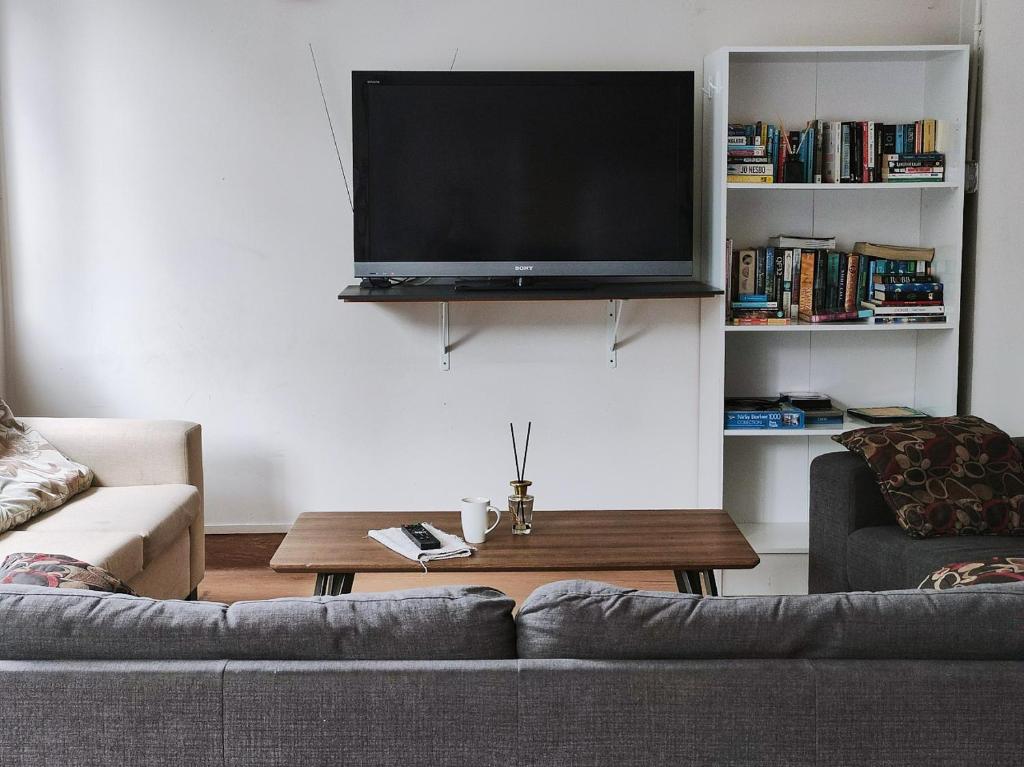 sala de estar con sofá y TV de pantalla plana en Newton Lodge Auckland, en Auckland