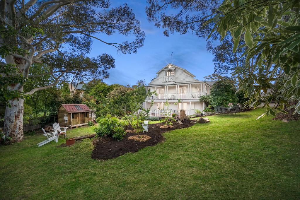 a large white house with a garden in front of it at 65 Main in Hepburn Springs