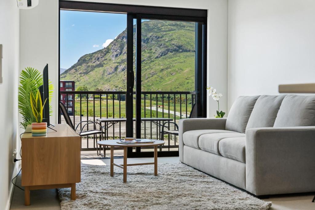 a living room with a couch and a view of a mountain at Toru Executive Apartment in Queenstown