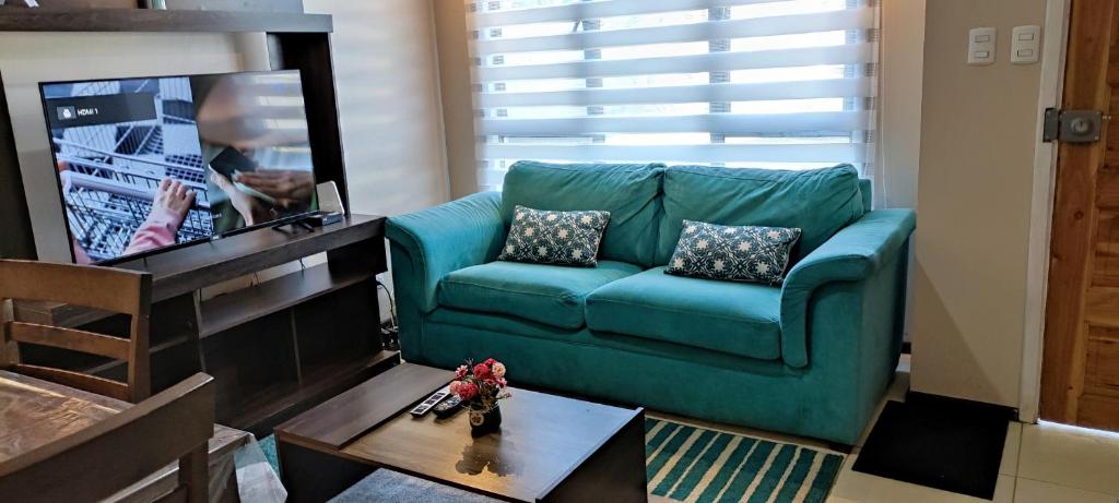 ein Wohnzimmer mit einem grünen Sofa und einem Tisch in der Unterkunft ENTRE CISNES 1, 2 y 3 Dorm in Valdivia