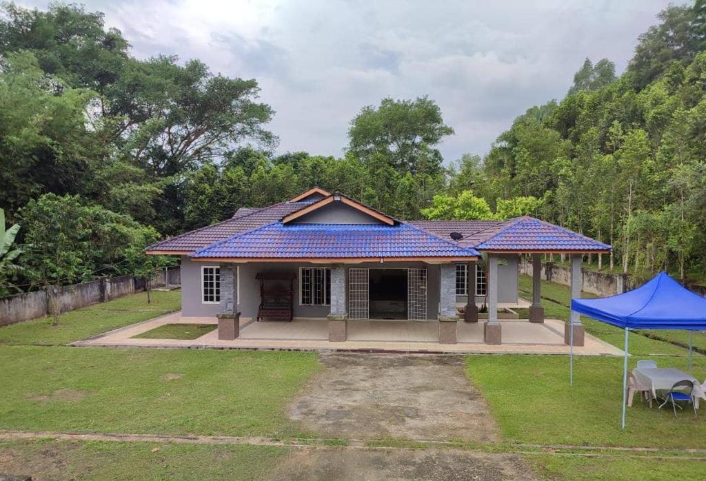 a small white house with a blue roof at Evergreen Xperience Guest House in Kuala Kubu Baharu
