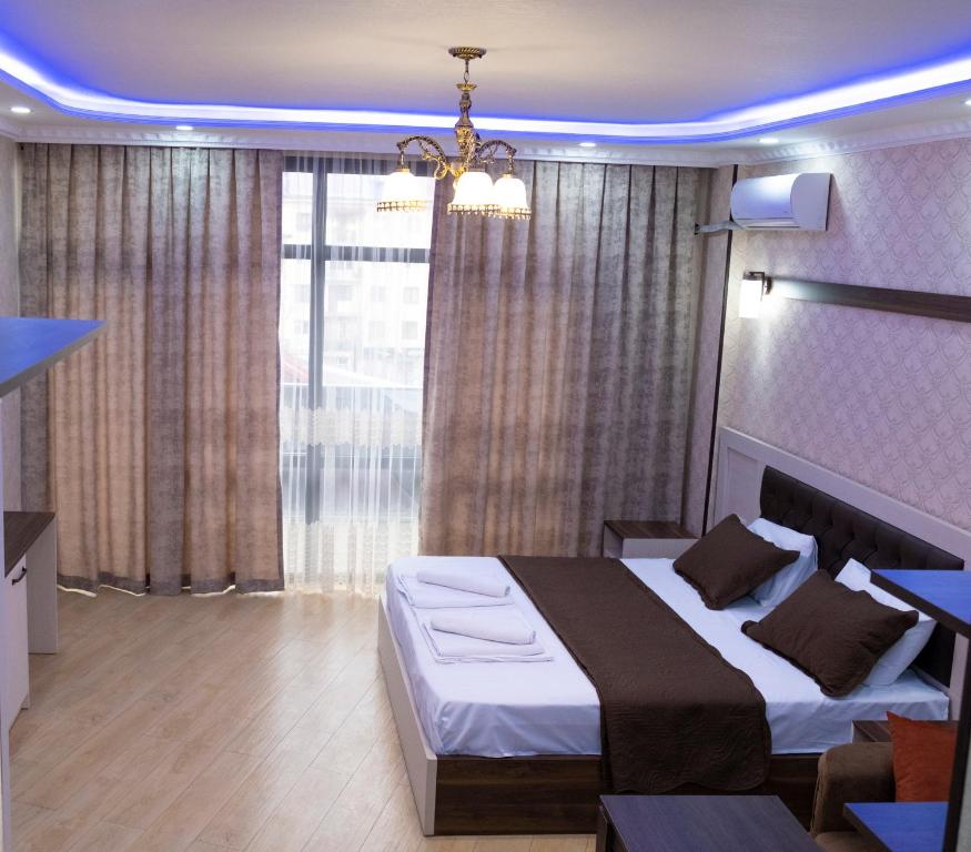 a bedroom with a large bed and a large window at EMEG Hotel in Batumi