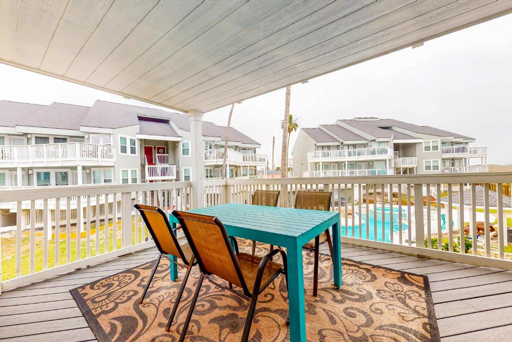 una mesa azul y sillas en una terraza con apartamentos en condominio en The Islander, en Port Aransas