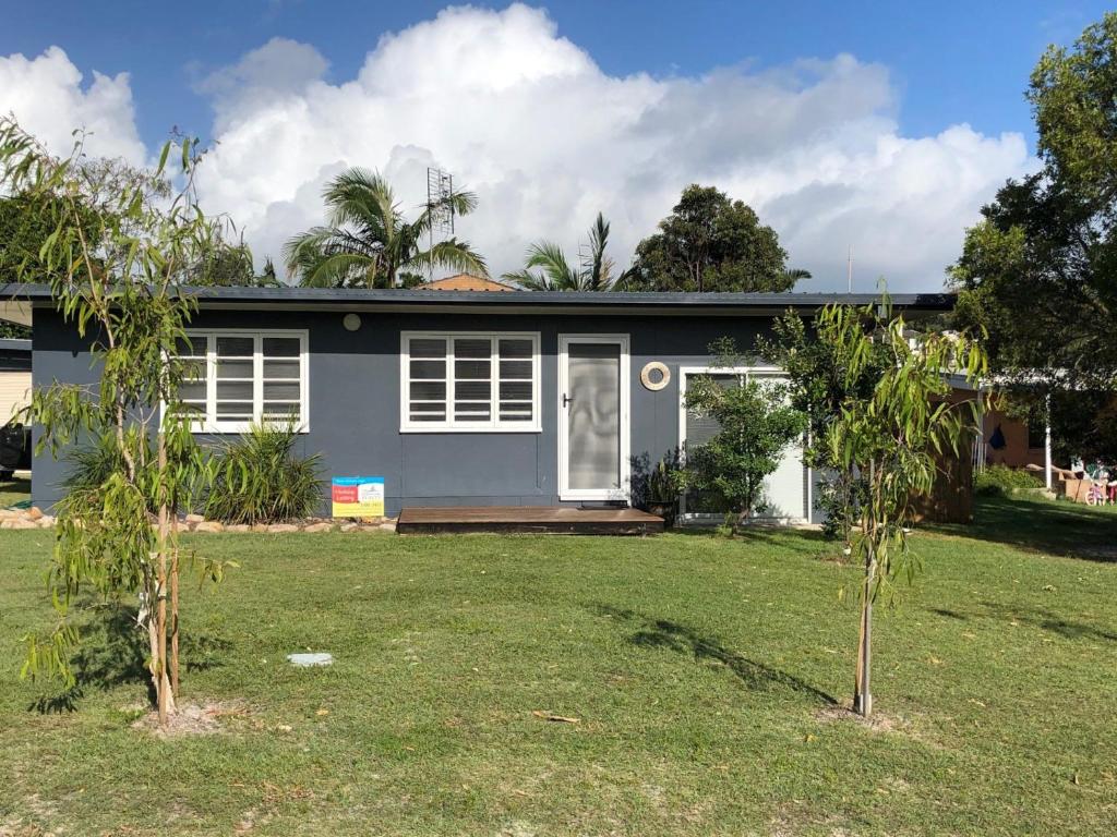 a house with two trees in front of it at 9 Indigo Avenue Rainbow Beach in Rainbow Beach