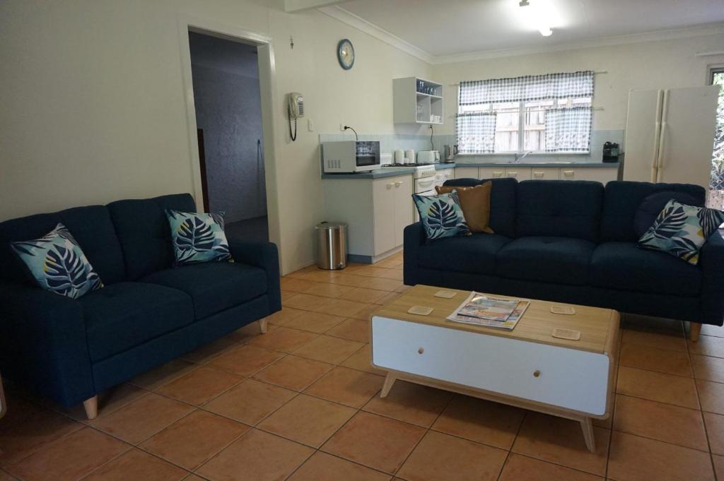 a living room with two couches and a coffee table at 11 Bomburra Court Rainbow Beach in Rainbow Beach