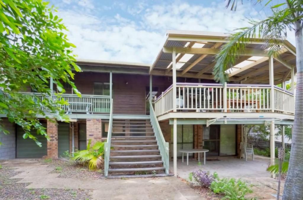 a house with a deck and stairs at 33 Cooloola Drive Rainbow Beach in Rainbow Beach