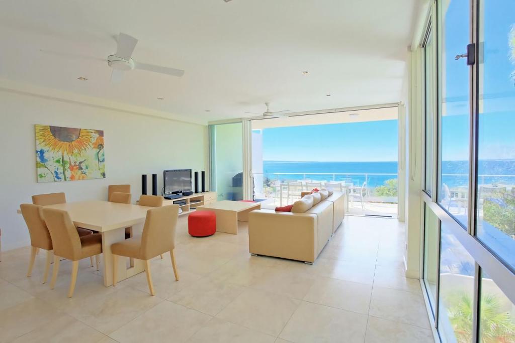 a living room with a couch and a table and chairs at Ocean View 1 Rainbow Beach in Rainbow Beach