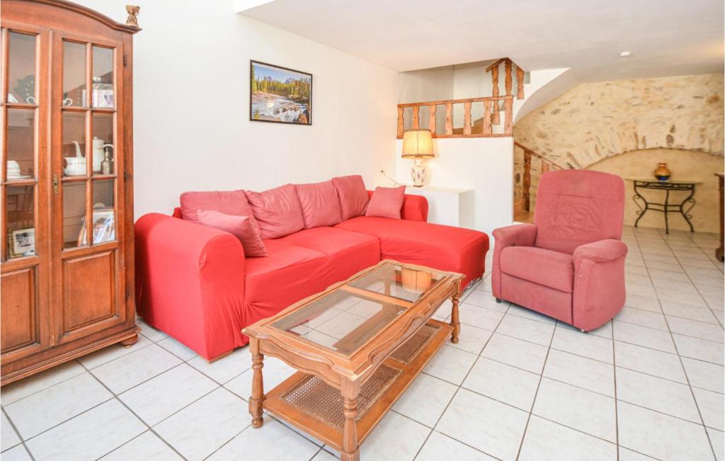 CessenonにあるNice Home In Cessenon Sur Orb With 2 Bedroomsのリビングルーム(赤いソファ、椅子2脚付)