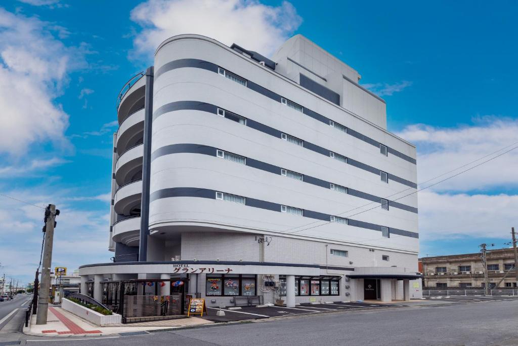 duży biały budynek na rogu ulicy w obiekcie HOTEL Gran Arenaホテルグランアリーナ w mieście Okinawa