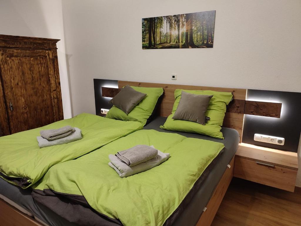 聖沃爾夫岡的住宿－Studio in einem Bauernhaus，一间卧室配有两张带绿床单和枕头的床。