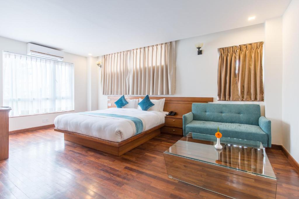 a hotel room with a bed and a couch and a table at Timber House in Kathmandu