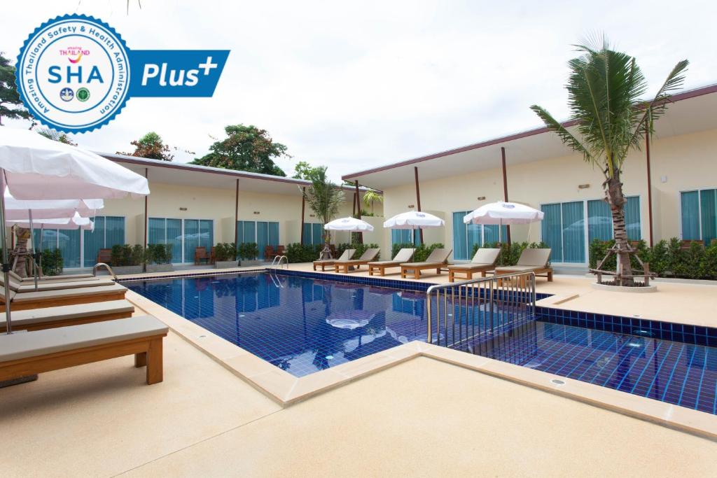 een zwembad van het hotel met banken en parasols bij Chalong Princess Pool Villa Resort SHA EXTRA PLUS in Chalong 
