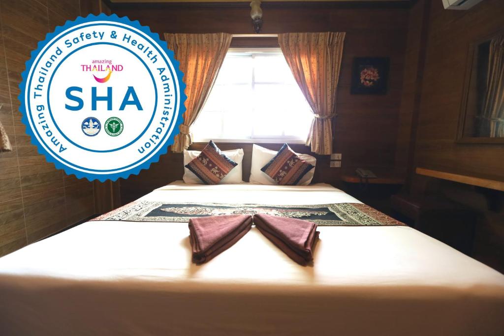 a hotel sha room with a bed with a sign on it at Thai Cozy House - SHA certified in Bangkok