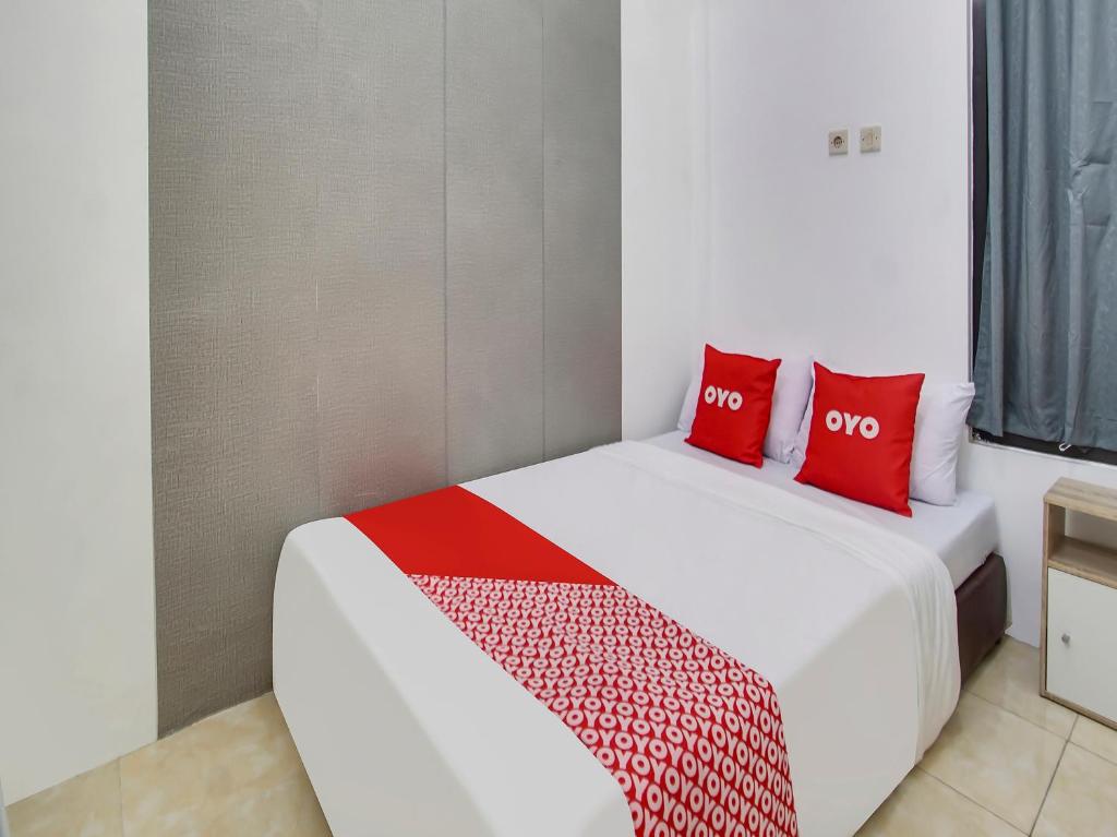 瑪琅的住宿－Forzando House Redpartner near Universitas Muhammadiyah Malang，宿舍间内的两张床,配有红色枕头