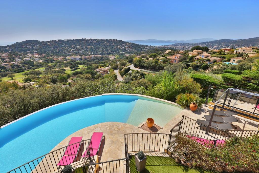 a swimming pool with chairs and a view of a valley at Villa-la-Sebastiane in Sainte-Maxime
