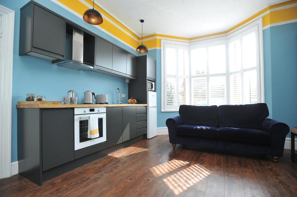 a kitchen with a black couch in a room at Beechurst Serviced Apartments in Cheltenham