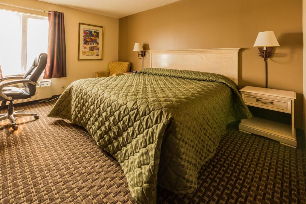 a hotel room with a bed and a chair at The Village Inn in Elora