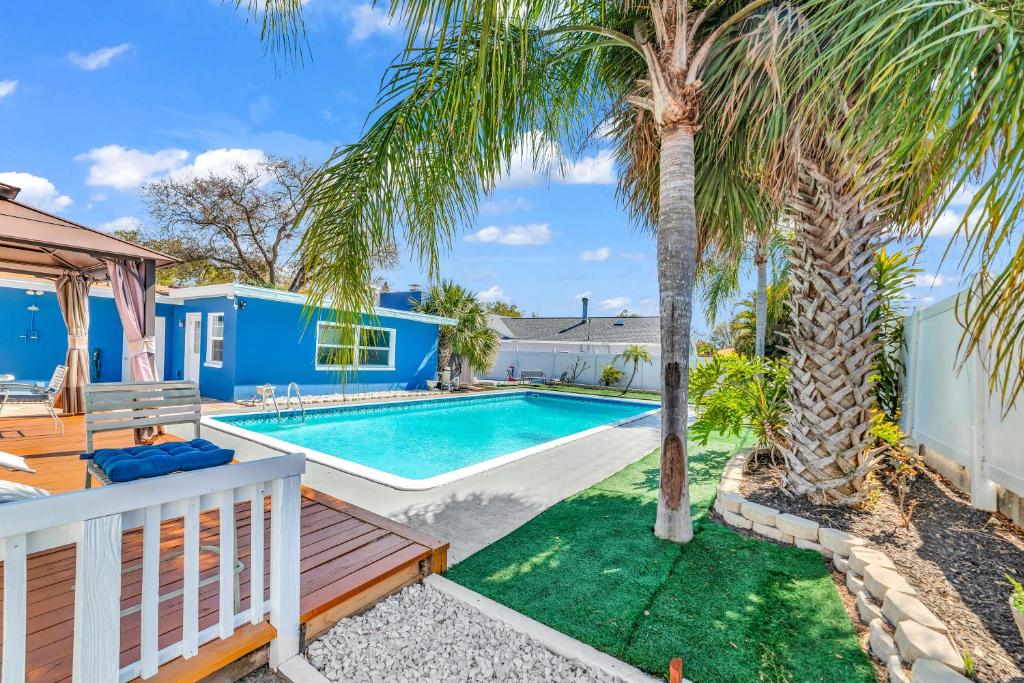 een zwembad met een palmboom en een huis bij The Blue Villa - Luxury Clearwater by BlueBellaEstate in Largo
