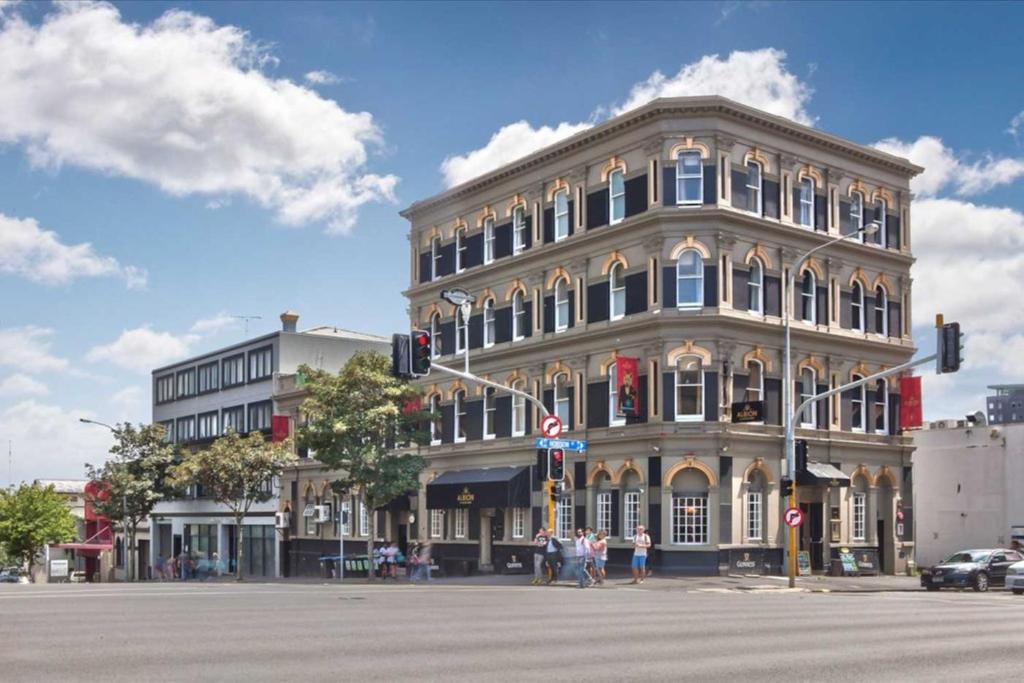 duży budynek na rogu ulicy w obiekcie Albion Hotel w Auckland