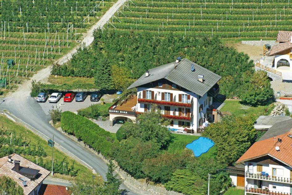 an aerial view of a house and a road with cars at Garni Rika in Parcines