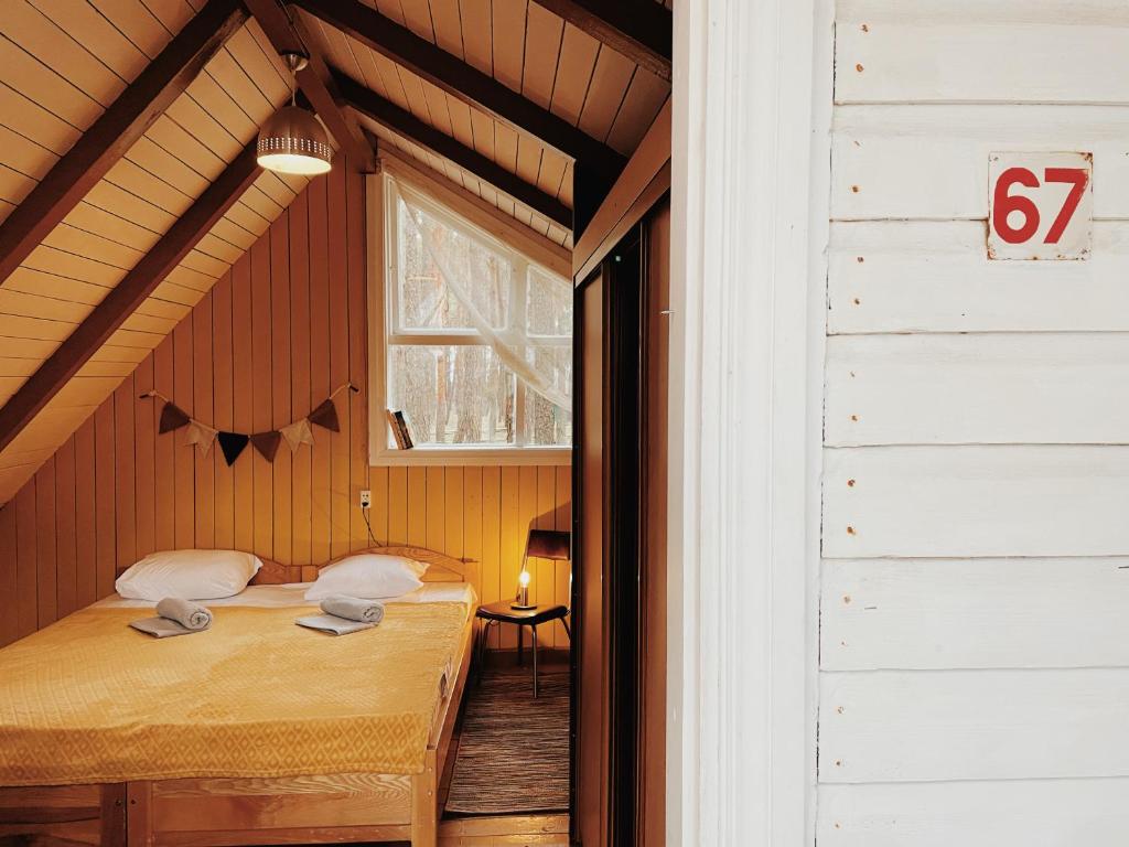 a bedroom with a bed in a room with a window at Energetikas • nameliai prie jūros in Šventoji