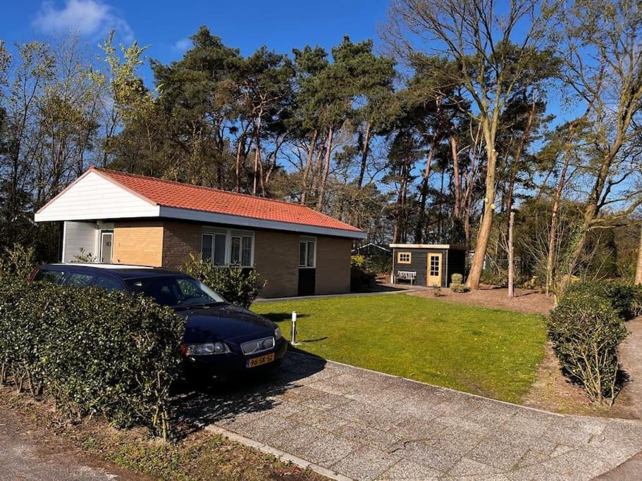 um carro estacionado em frente a uma casa em Fijne plek met eigen bos 2000m2 en GRATIS linnen en handdoeken!! em Denekamp