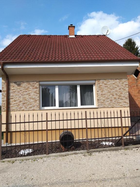 a house with a fence in front of it at Nefelejcs Nyaraló-Vendégház in Dunasziget