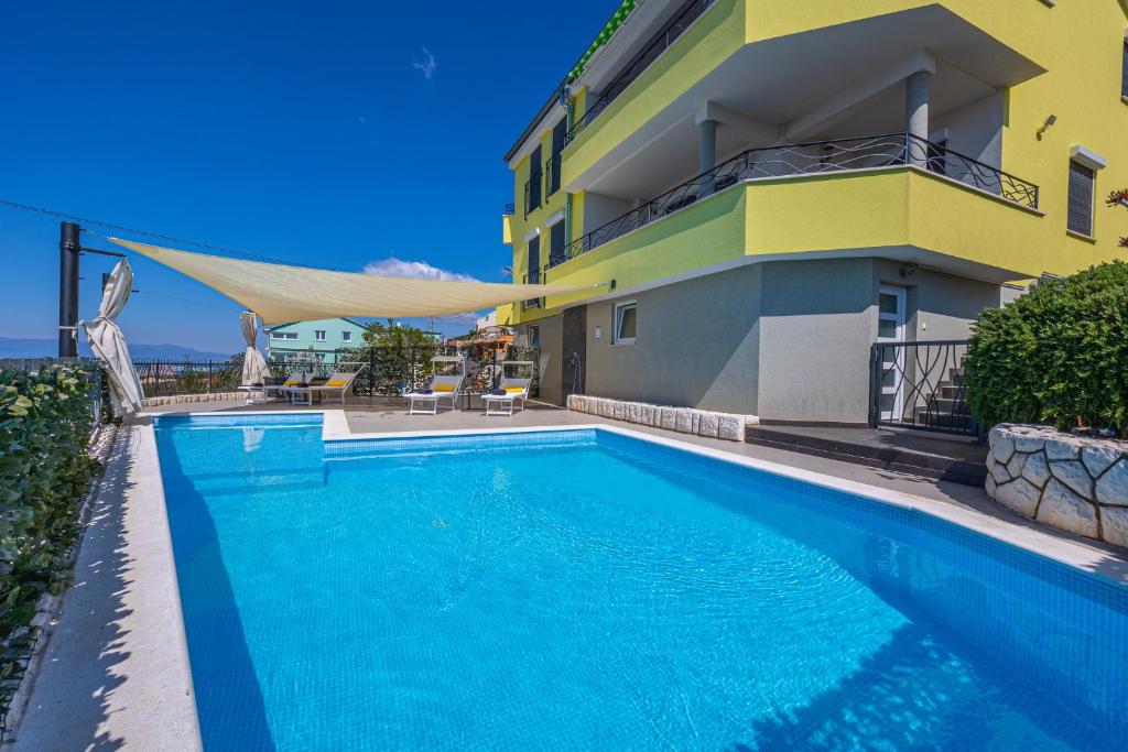 a swimming pool in front of a building at Sun Villa in Dramalj