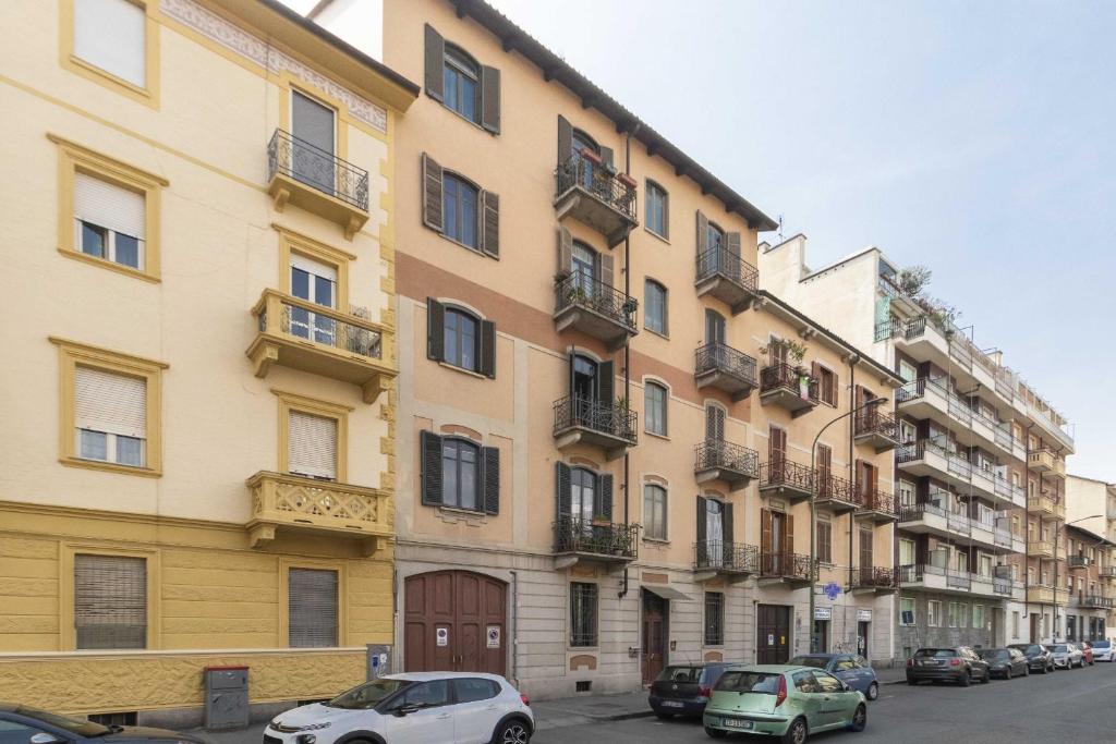 wysoki budynek z samochodami zaparkowanymi przed nim w obiekcie Casa di Diana e Francesco in zona Cenisia by Wonderful Italy w Turynie