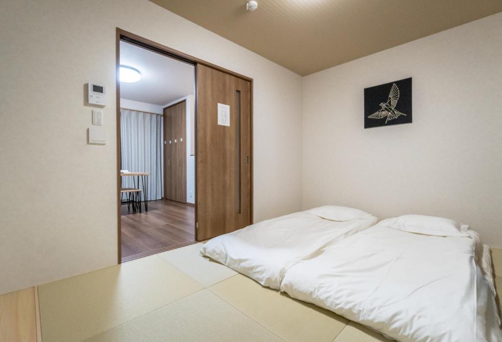 um quarto com uma cama e um espelho grande em HANASTAY花渓居 · 澄（KIYOSI) em Osaka