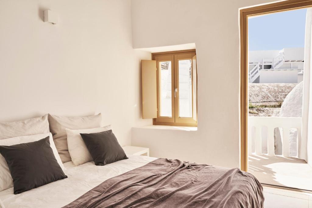 sypialnia z dużym łóżkiem i lustrem w obiekcie TOWN BOX w mieście Mykonos