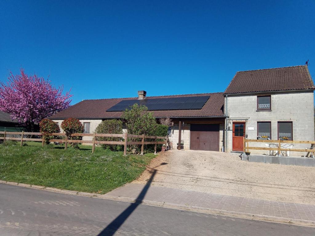a white house with a brown roof and a driveway at Gite à la Ferme in Rouvroy