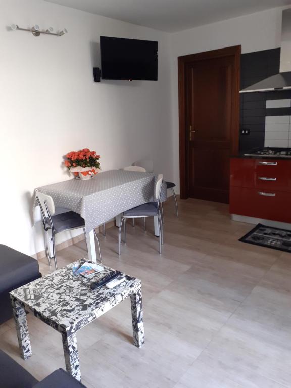 uma sala de estar com uma mesa e cadeiras e uma televisão em Casa Dylan em Cagliari