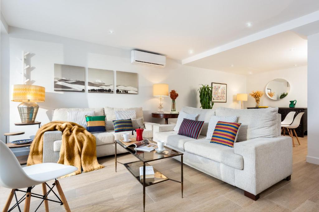 ein Wohnzimmer mit einem Sofa und einem Tisch in der Unterkunft Plaza España, acogedor apartamento con patio by OUTIN in Sevilla