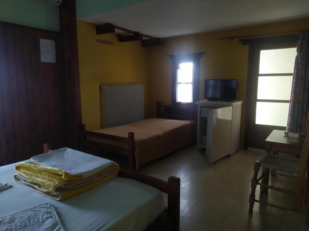 pokój hotelowy z dwoma łóżkami i telewizorem w obiekcie Triple studio room in Mylopotamos Beach w mieście Tsagarada
