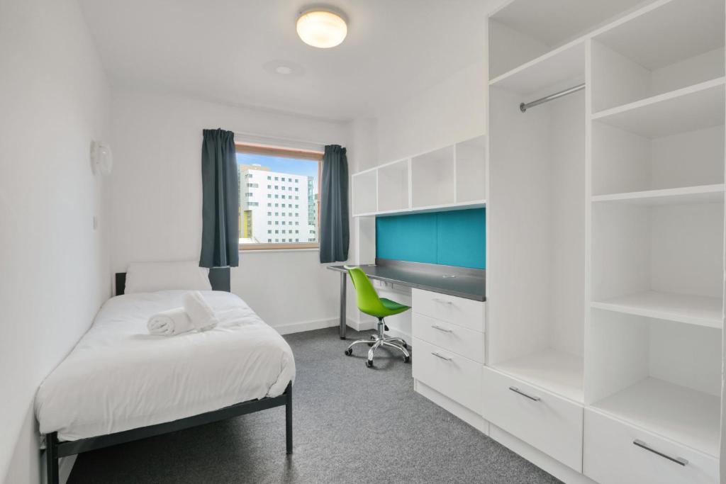 a bedroom with a bed and a desk and a chair at Central Single Room With Shared Kitchen in Luton in Luton