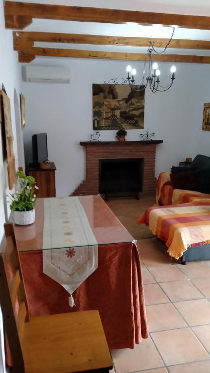 salon ze stołem i kominkiem w obiekcie Casa Cueva Sierra Nevada - Monachil w mieście Monachil