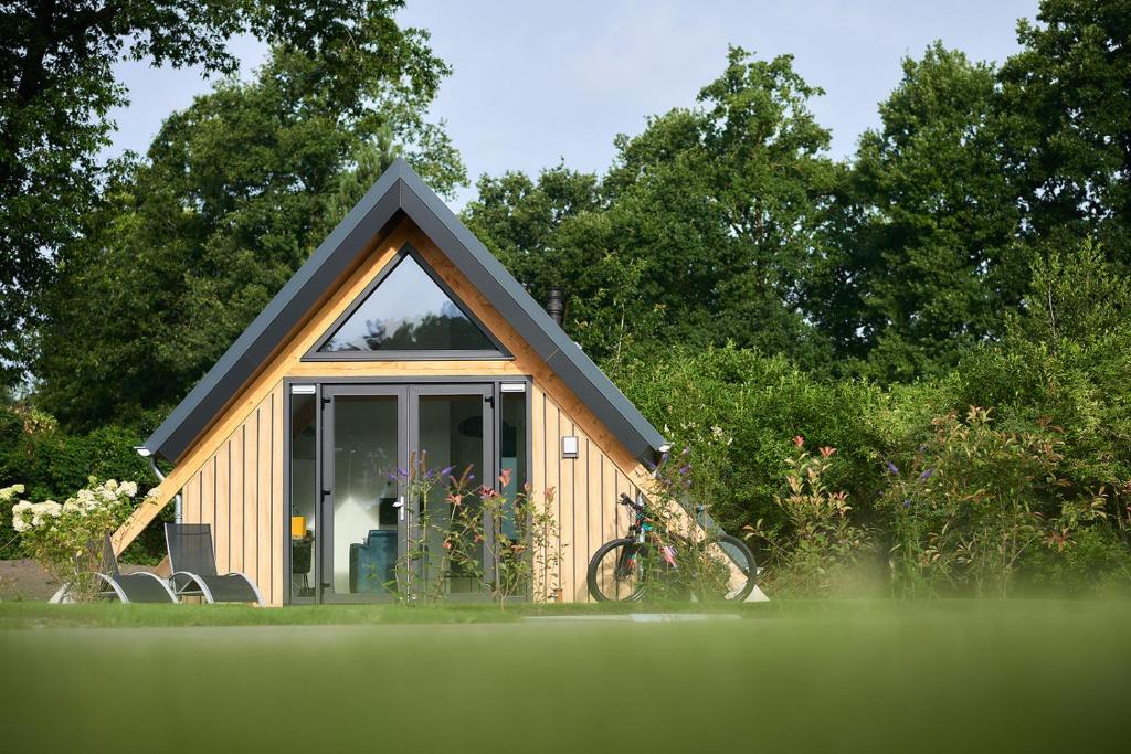 a small house with a bike parked in front of it at Wellness Lodges x De IJsvogel in Voorthuizen