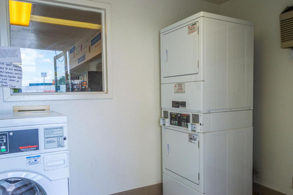 a laundry room with two refrigerators and a washer at Motel 6-Ardmore, OK in Ardmore