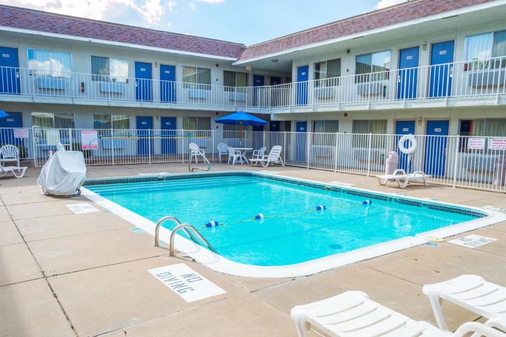 a swimming pool in front of a building with chairs at Motel 6-Ardmore, OK in Ardmore