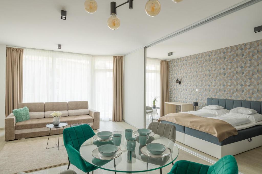 um quarto com uma cama, uma mesa e cadeiras em Parizs Garden Apartments em Debrecen