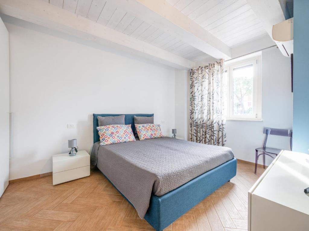 - une chambre avec un lit bleu et une fenêtre dans l'établissement La Marina Apartment with Patio & Parking, à Fano