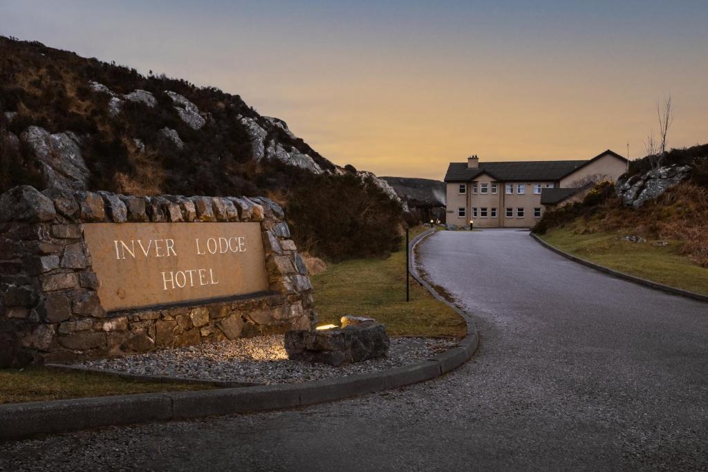 a sign that reads river lodge hotel next to a road at Inver Lodge in Lochinver