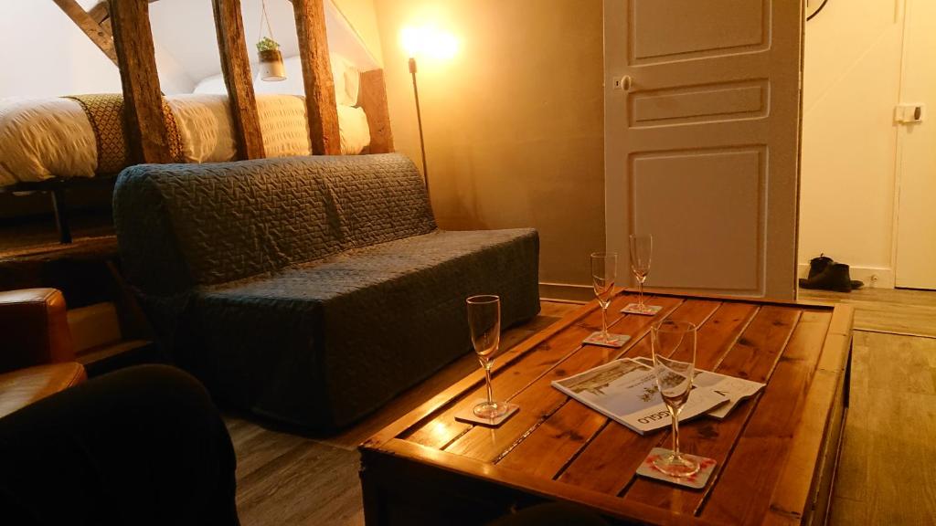 um quarto com uma mesa com dois copos de vinho em Nuits au Grenier de Chartres em Chartres