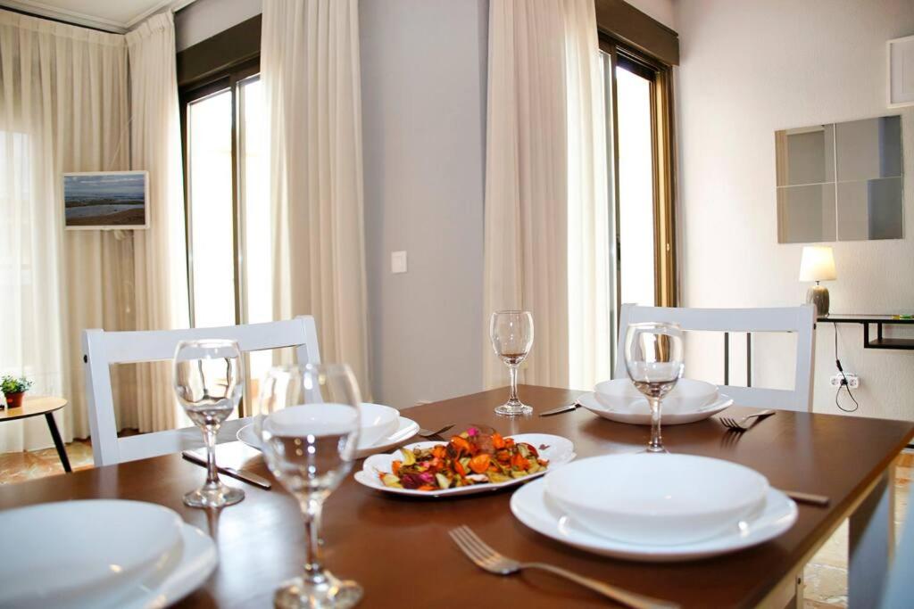uma mesa com pratos de comida e copos de vinho em Castaños apartment with AC em Alicante