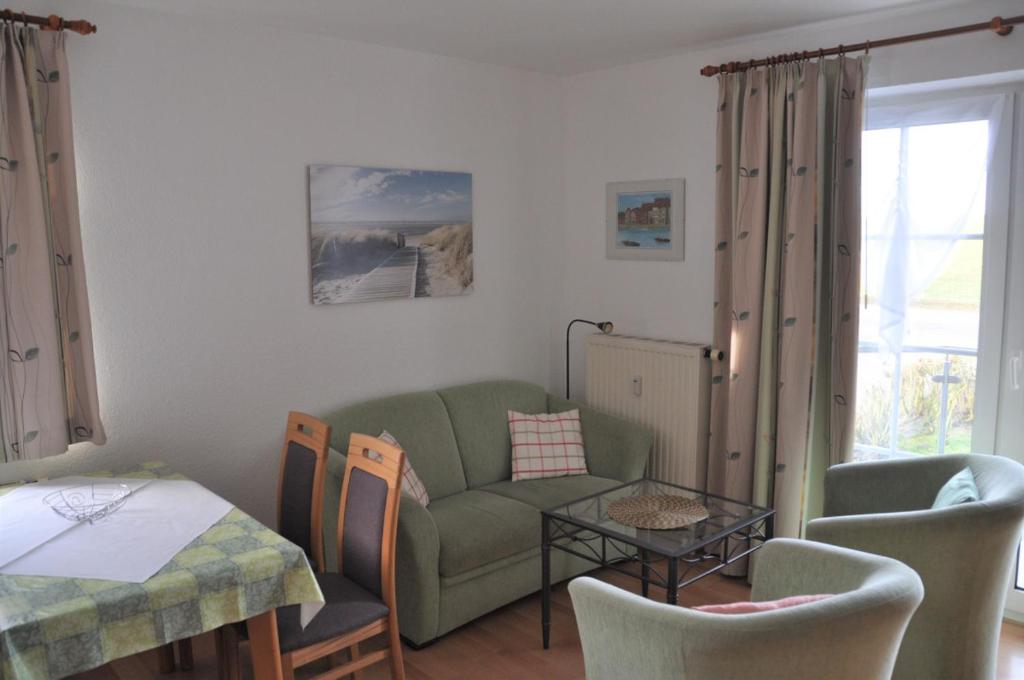 ein Wohnzimmer mit einem Sofa und einem Tisch in der Unterkunft Nordseedüne, Ferienwohnung 3 in Cuxhaven