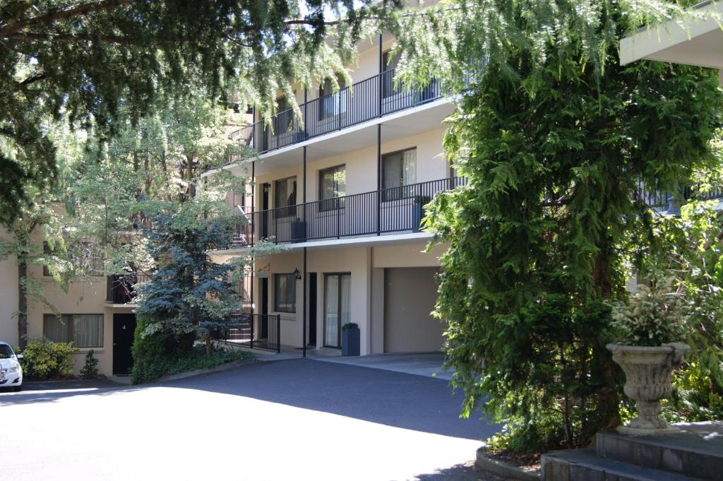 ein Apartmenthaus mit Bäumen davor in der Unterkunft Grosvenor Court Apartments in Hobart