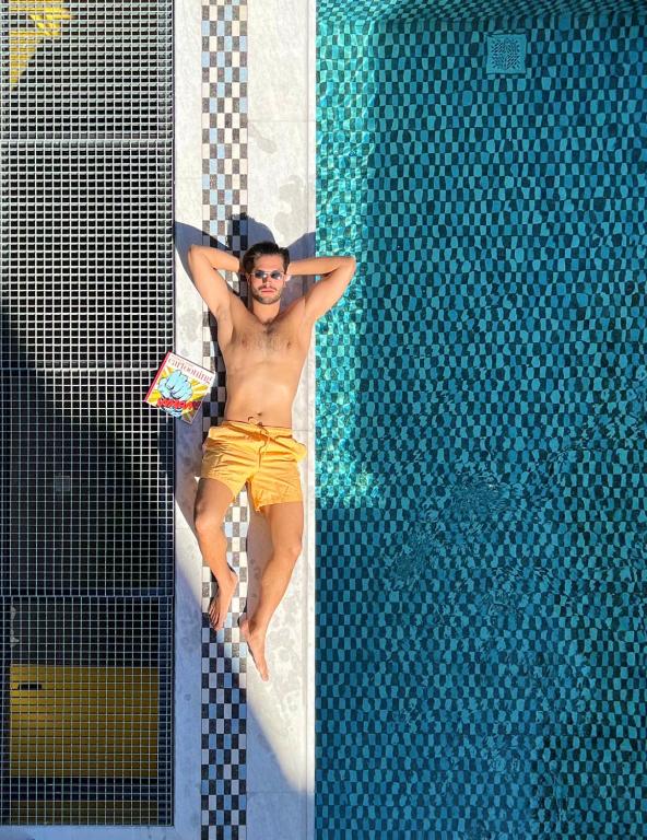 een man op een vlot naast een zwembad bij 3 Pines Design Living in Heraklion