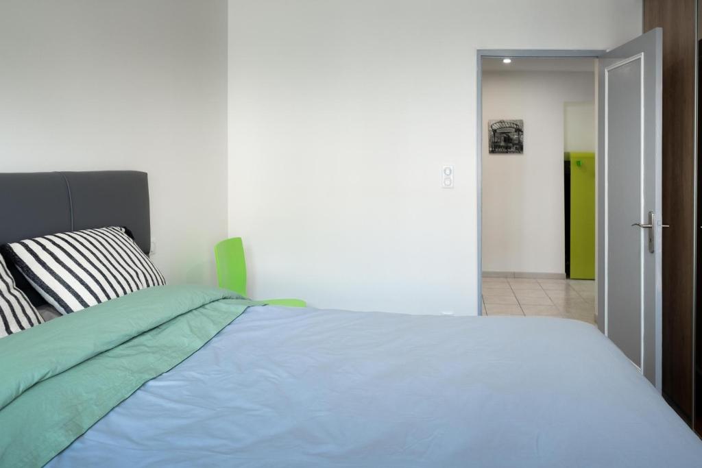 um quarto com uma cama com um edredão azul em 55 m²/ Chez LÔrette/ 250m LAKE/ PRIVATE PARKING em Annecy